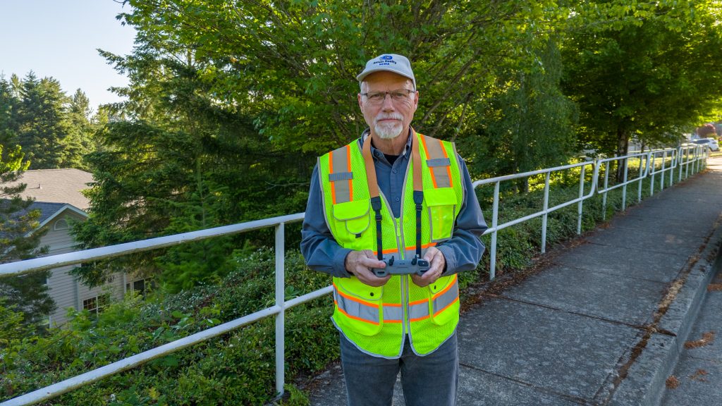 a drone pilot looks at the drone he's controlling